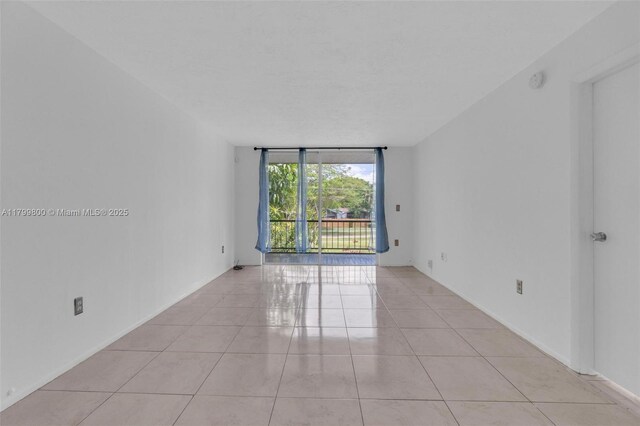 7300 NW 17th St Unit 203, Plantation, FL 33313 - empty room featuring expansive windows and light tile patterned flooring