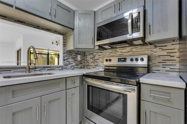 20260 NE 3rd Ct Unit 5, Miami, FL 33179 - kitchen featuring appliances with stainless steel finishes, a sink, gray cabinets, and backsplash