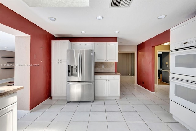 2730 NW 105th Ter, Coral Springs, FL 33065 - kitchen featuring stainless steel fridge, white double oven, tasteful backsplash, white cabinetry, and baseboards