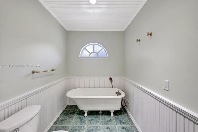 2730 NW 105th Ter, Coral Springs, FL 33065 - bathroom featuring a wainscoted wall, toilet, and a freestanding bath
