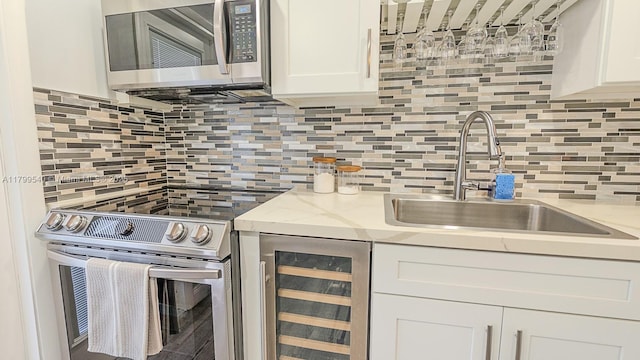 kitchen featuring stainless steel appliances, beverage cooler, a sink, and tasteful backsplash