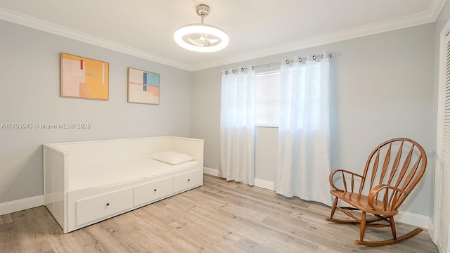 living area with crown molding, light wood-type flooring, and baseboards