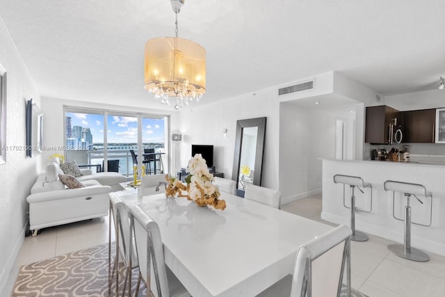 dining room featuring light tile patterned floors, a chandelier, and baseboards
