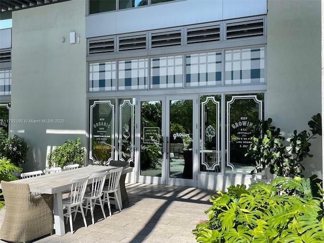 doorway to property featuring outdoor dining area and stucco siding