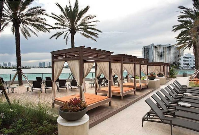 view of home's community featuring a pergola, a city view, and a deck with water view