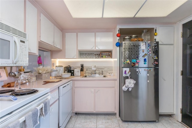 18555 NE 14th Ave Unit 612, Miami, FL 33179 - kitchen featuring white appliances, a sink, light countertops, white cabinets, and light tile patterned floors