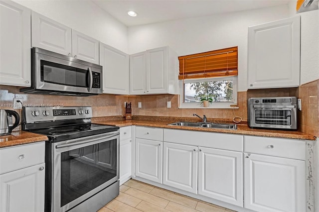 9821 W Fern Ln, Miramar, FL 33025 - kitchen with appliances with stainless steel finishes, a sink, white cabinets, tasteful backsplash, and recessed lighting