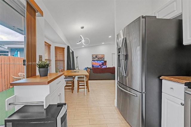 9821 W Fern Ln, Miramar, FL 33025 - kitchen with stainless steel fridge with ice dispenser, lofted ceiling, white cabinets, recessed lighting, and hanging light fixtures