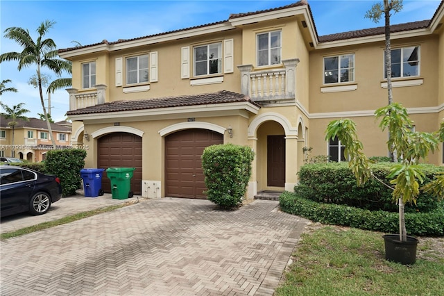 townhome / multi-family property featuring driveway, stucco siding, and a garage