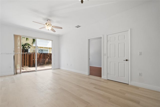 spare room featuring ceiling fan, light wood-style flooring, and baseboards