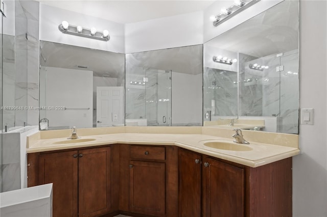 bathroom featuring a marble finish shower and double vanity