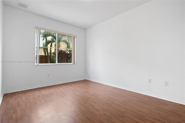 empty room with dark wood-style flooring and baseboards