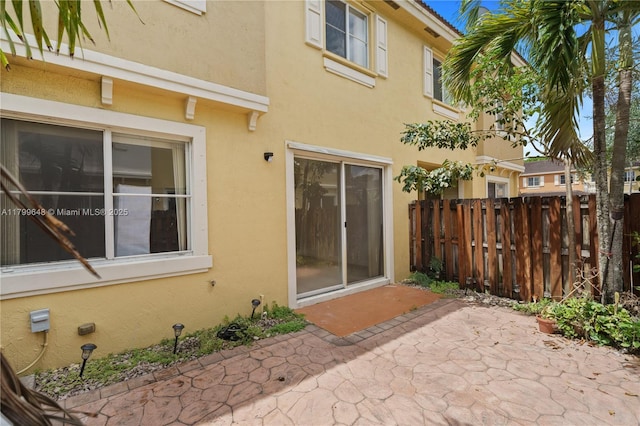 back of property featuring stucco siding, a patio area, and fence