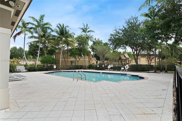 community pool with fence and a patio