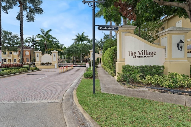 view of decorative road featuring curbs and a gated entry