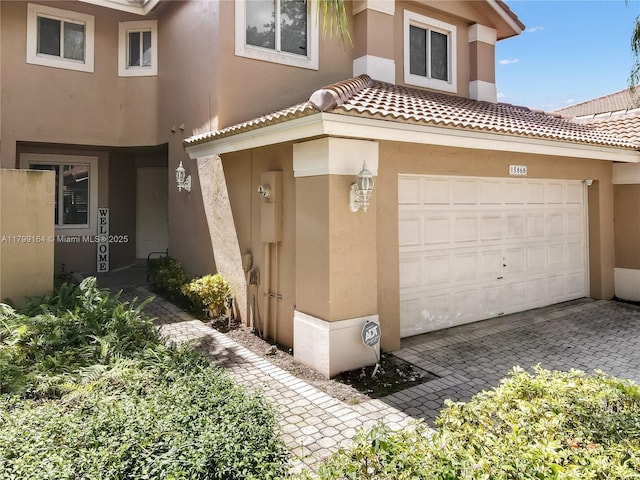 view of front of house featuring stucco siding, driveway, and a tile roof