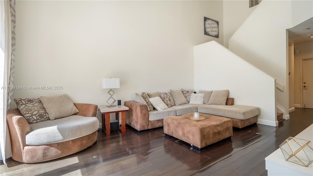 living area with dark wood-style flooring, stairway, and baseboards