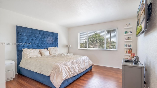 bedroom with wood finished floors and baseboards