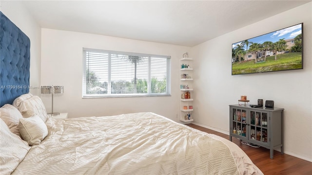 bedroom featuring wood finished floors and baseboards