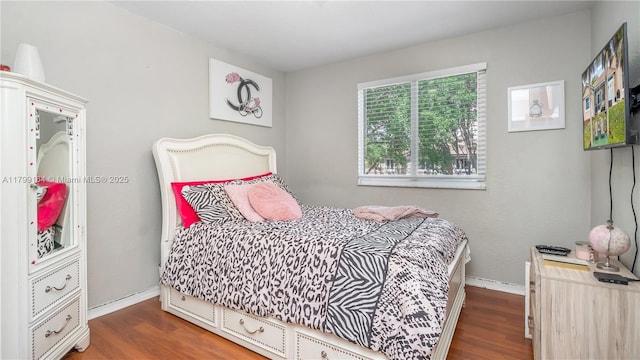 bedroom with wood finished floors and baseboards