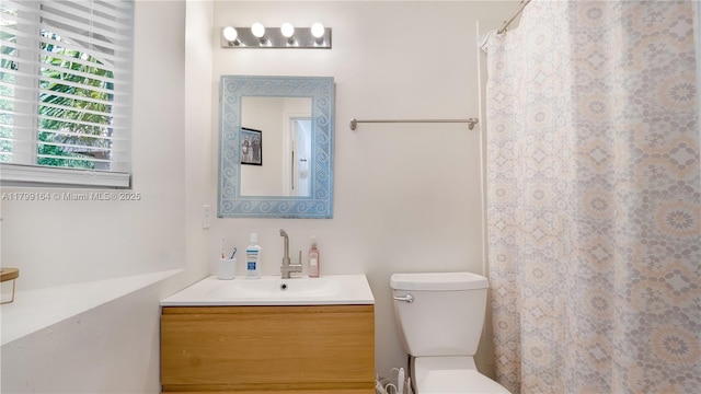 bathroom featuring toilet, vanity, and a shower with shower curtain