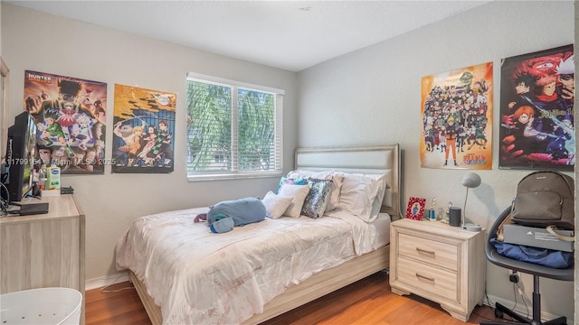 bedroom featuring wood finished floors and baseboards