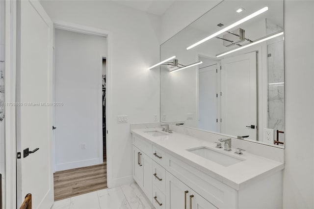 full bathroom featuring marble look tiles, double vanity, and baseboards