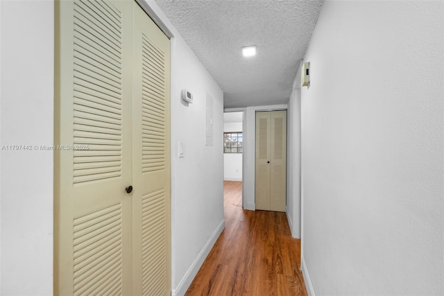 933 NE 199th St Unit 207, Miami, FL 33179 - hall with a textured ceiling, wood finished floors, and baseboards