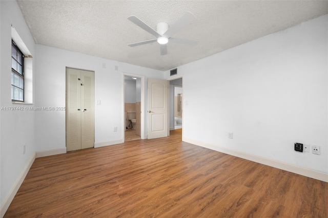 933 NE 199th St Unit 207, Miami, FL 33179 - unfurnished bedroom with wood finished floors, a textured ceiling, baseboards, a closet, and a ceiling fan