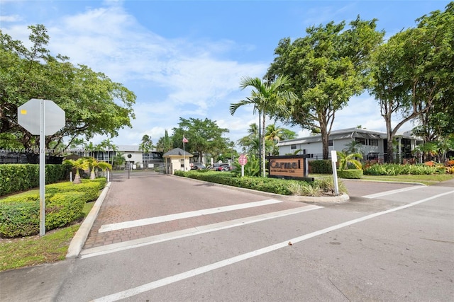 933 NE 199th St Unit 207, Miami, FL 33179 - view of decorative street featuring traffic signs, a gate, a gated entry, and curbs
