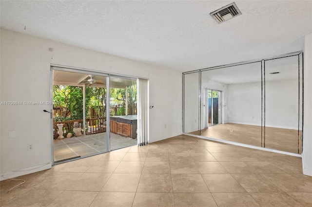 450 SE 7th St Unit 230, Dania Beach, FL 33004 - unfurnished bedroom featuring access to outside, a textured ceiling, and light tile patterned floors