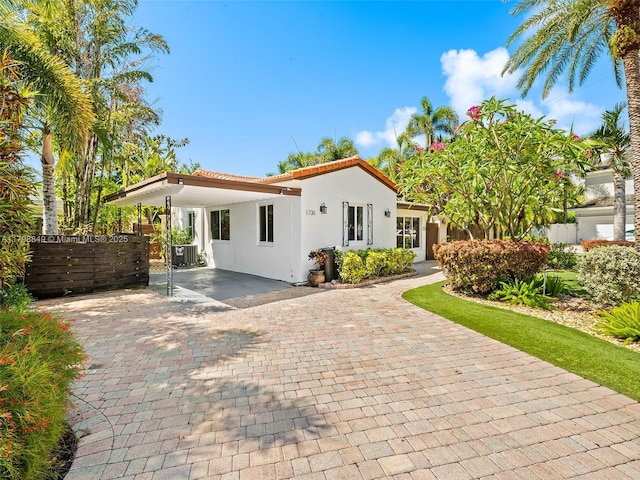 1730 NE 16th St, Fort Lauderdale, FL 33304 - view of front facade featuring stucco siding, a tile roof, and driveway