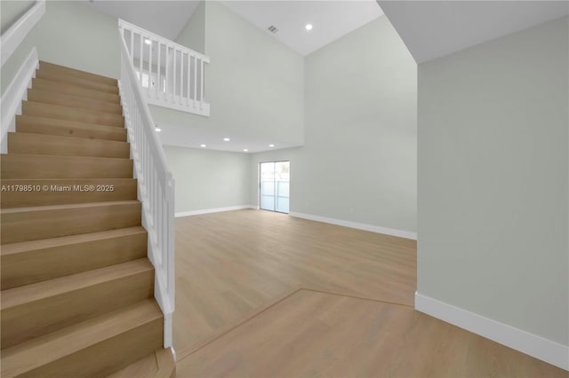 20076 NW 85th Ave, Hialeah, FL 33015 - stairway featuring baseboards, wood finished floors, a towering ceiling, and recessed lighting