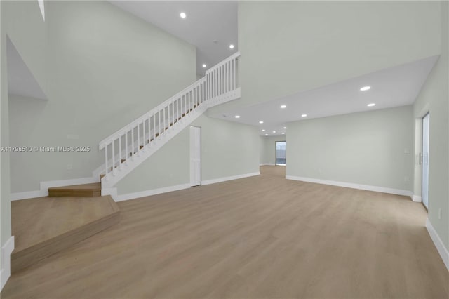 20076 NW 85th Ave, Hialeah, FL 33015 - unfurnished living room featuring stairway, recessed lighting, wood finished floors, baseboards, and a high ceiling