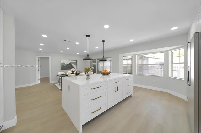 20076 NW 85th Ave, Hialeah, FL 33015 - kitchen featuring light wood finished floors, white cabinets, a center island, recessed lighting, and light countertops