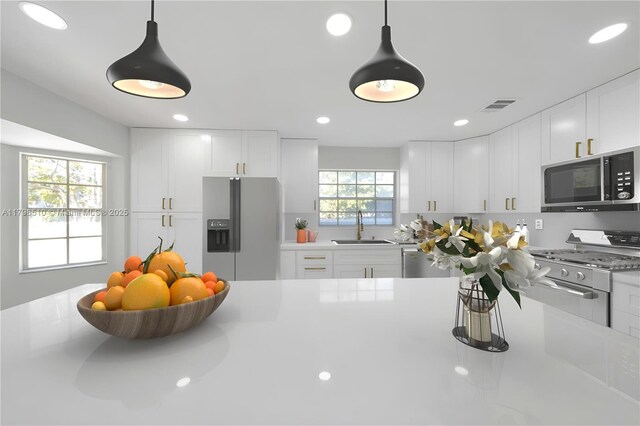 20076 NW 85th Ave, Hialeah, FL 33015 - kitchen with stainless steel appliances, a sink, white cabinets, pendant lighting, and light countertops