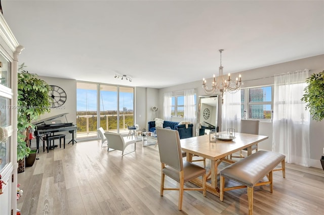 dining area featuring a chandelier, light wood-type flooring, and plenty of natural light