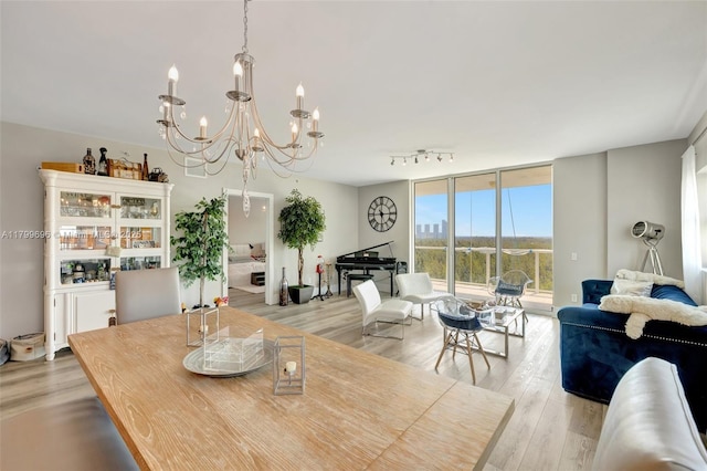 dining room featuring a chandelier, light wood-style floors, and floor to ceiling windows
