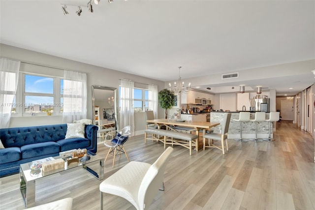 living room with a chandelier and light wood-type flooring