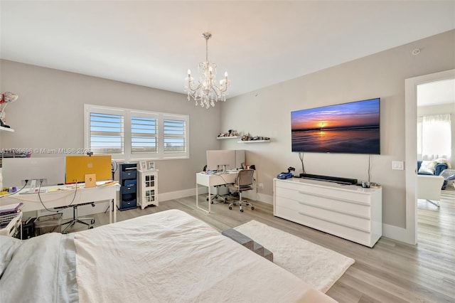 bedroom with a chandelier, an office area, wood finished floors, and baseboards
