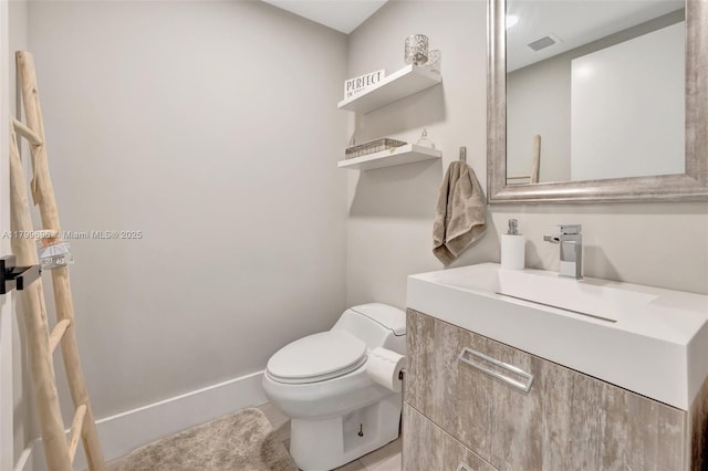 half bathroom with toilet, vanity, and tile patterned floors