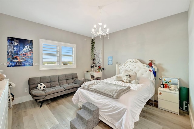bedroom with light wood-style flooring and a chandelier