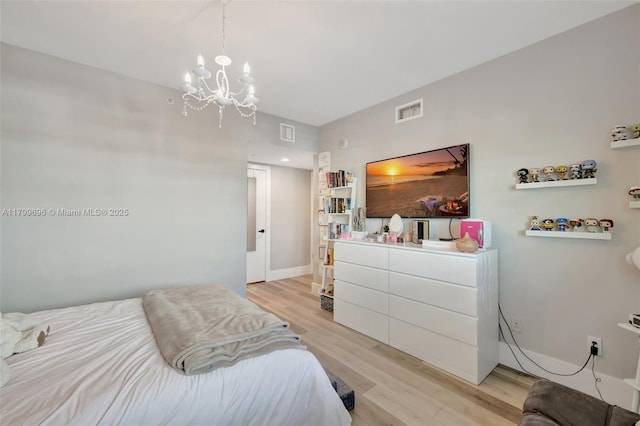 bedroom featuring light wood-style floors and a chandelier