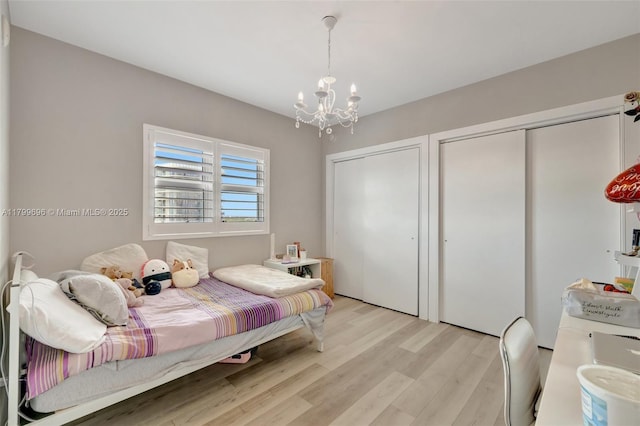 14951 Royal Oaks Ln Unit 1409, North Miami, FL 33181 - bedroom with a chandelier, light wood-style floors, and multiple closets