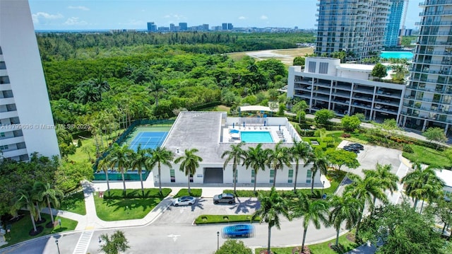 view of urban area featuring a pool and a forest