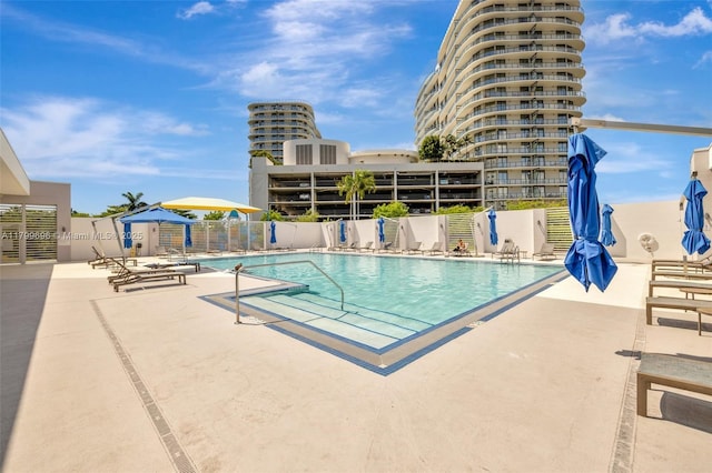 community pool featuring fence and a patio