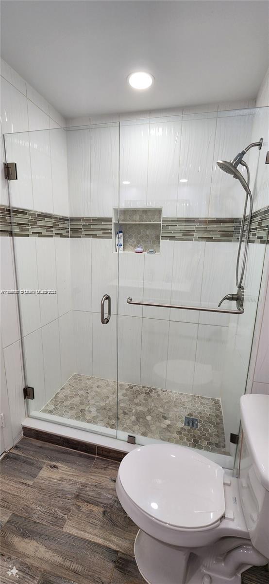 16624 Greens Edge Cir Unit 75, Weston, FL 33326 - bathroom with toilet, a stall shower, and wood finished floors