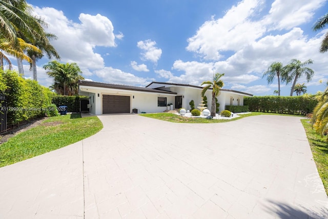 7345 N Oakmont Dr, Hialeah, FL 33015 - view of front of house with a garage, stucco siding, driveway, and a tile roof