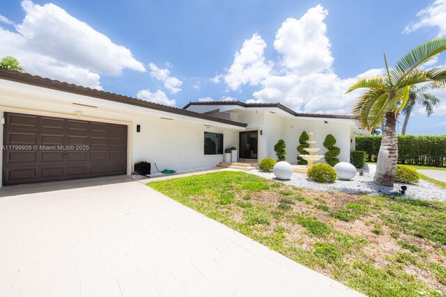7345 N Oakmont Dr, Hialeah, FL 33015 - mediterranean / spanish-style house featuring stucco siding, an attached garage, and driveway