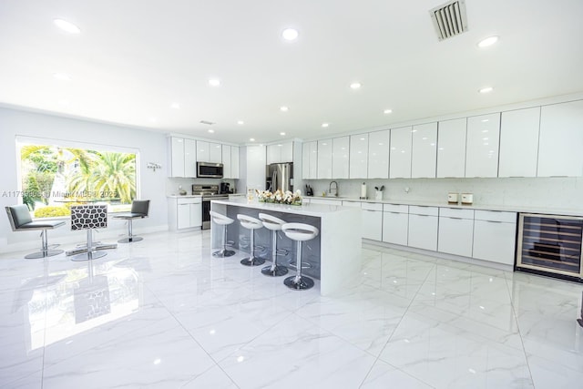 7345 N Oakmont Dr, Hialeah, FL 33015 - kitchen featuring stainless steel appliances, wine cooler, modern cabinets, a kitchen breakfast bar, and a sink